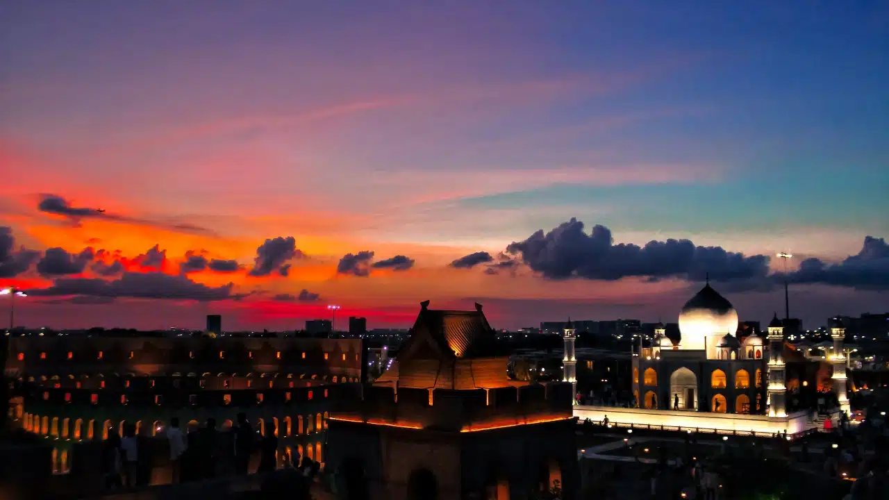 Sunset view of Kolkata, India, featuring illuminated cultural landmarks, historic architecture, and a vibrant city skyline under colorful evening skies.
